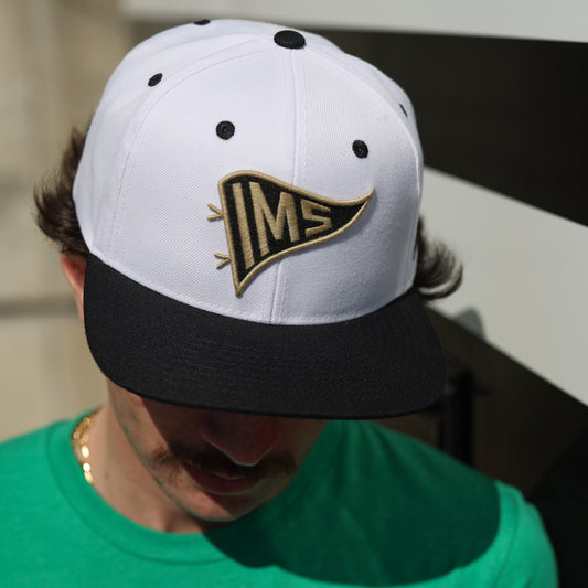 Indianapolis Motor Speedway Pennant Snapback Hat In White, Black & Gold - Front View On Model